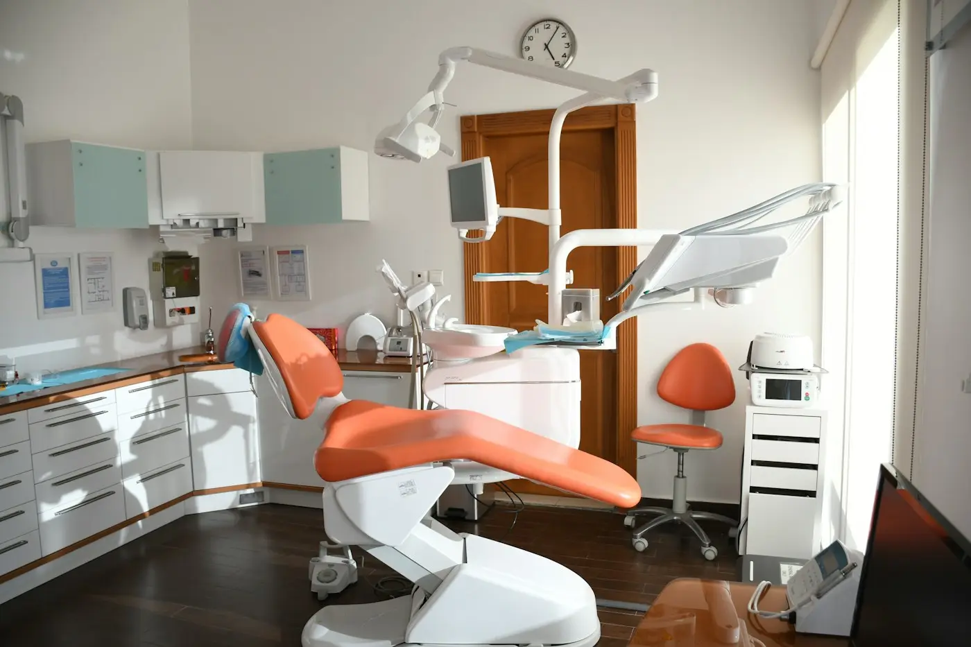Sillón dental naranja en un consultorio iluminado